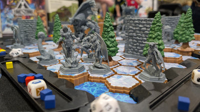 TimeStrike Shadow of Fear miniatures close-up — gray unpainted hero and monster minis on icy hex terrain with pine trees and stone walls for tabletop battle