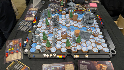 TimeStrike Shadow of Fear gameplay scene — full Frozen Tundra hex battlefield with painted miniatures, pine trees, stone walls and dice on SOURCE foundation at convention table