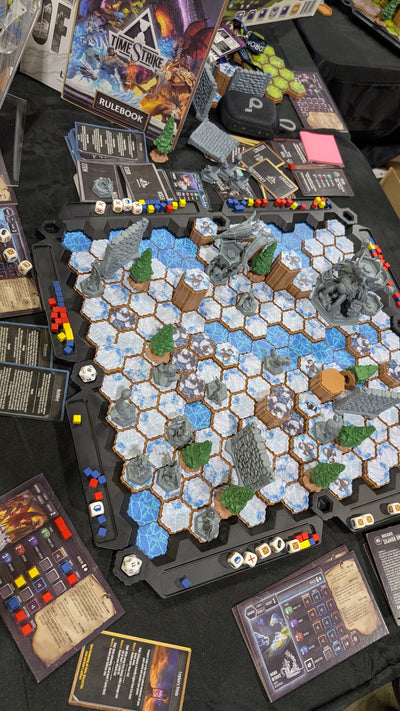 TimeStrike Shadow of Fear table view — Frozen Tundra hex battlefield setup with miniatures, trees and rulebook for full game-night convention play
