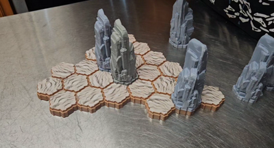 SOURCE Stone Pillar unpainted grey miniatures on hex terrain — multiple pillar sizes shown in play for TimeStrike & tabletop wargaming